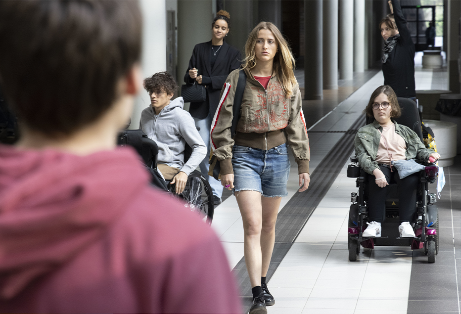 Dans la série Toulouse Lautrec : une jeune fille marche dans les couloirs entourées de d'un homme et d'une femme en fauteuils roulants
